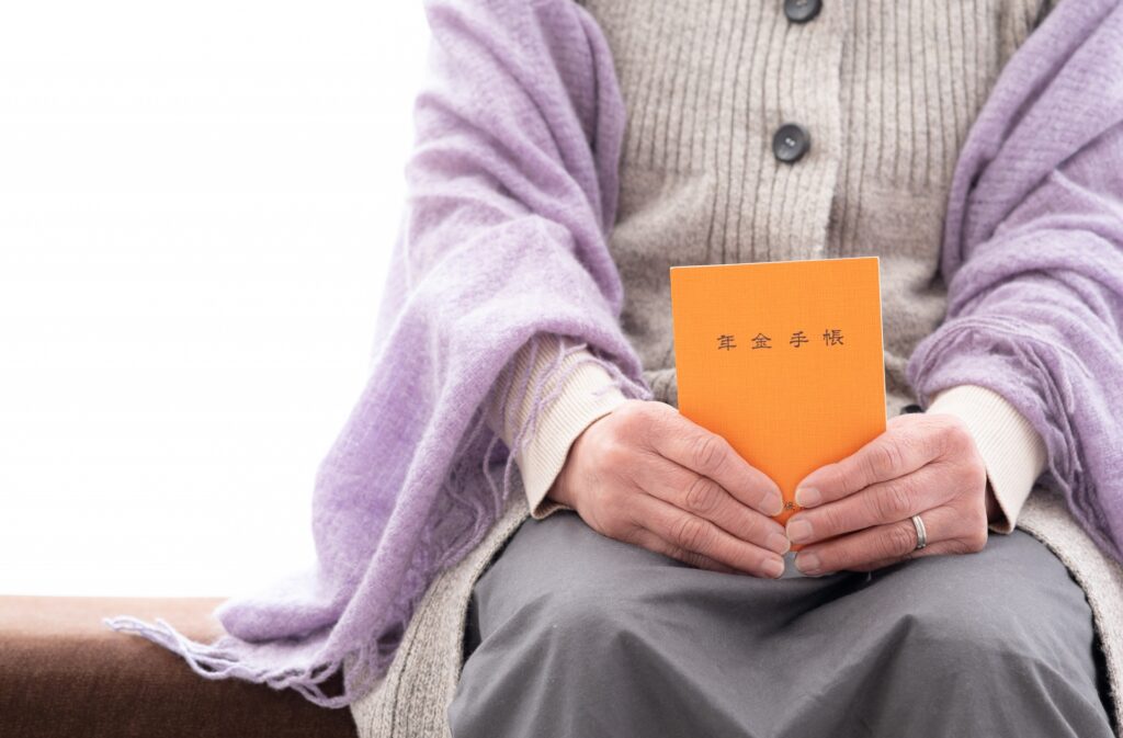 年金手帳を持つ高齢者女性